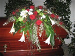 Dekorativer Sargschmuck mit roten Rosen und weißen Lilien